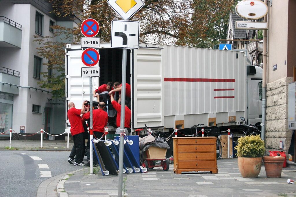 Entrümpelungsteam trägt Kartons und Möbel aus einem gekauften Haus